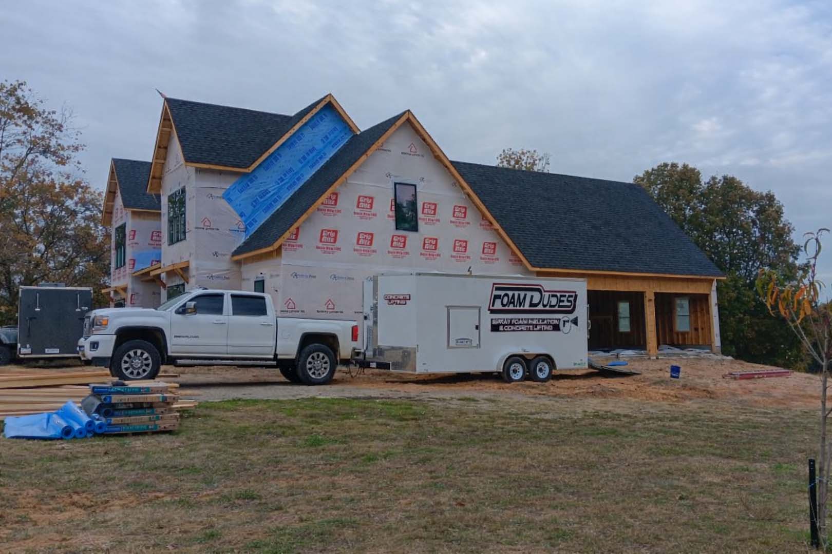 image of our Foam Dudes truck with the back open, after we just arrived to a property in Arkansas to apply spray foam insulation
